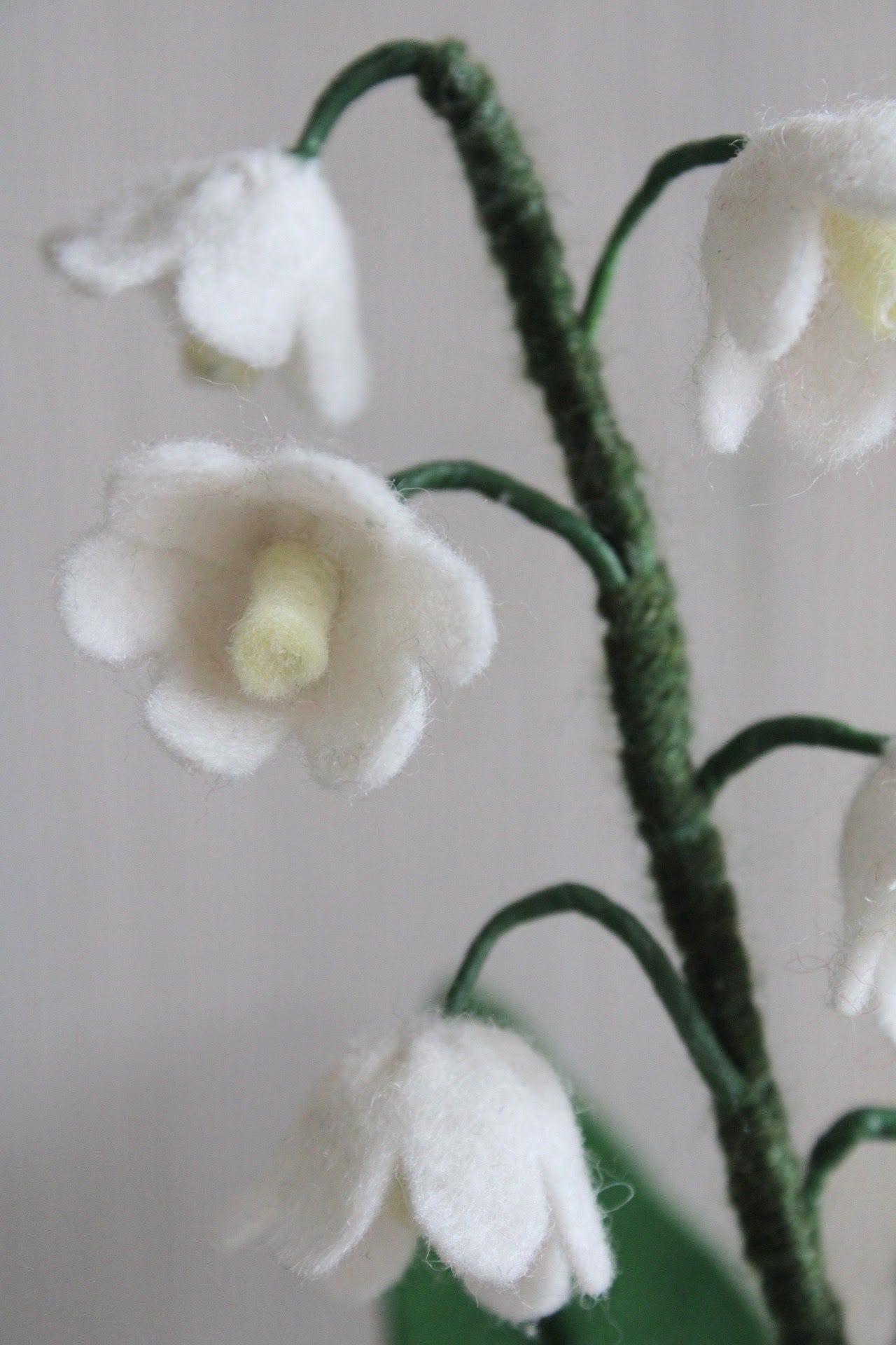 Handgemaakt lelietje-van-dalen van vilt met delicate witte bloemetjes en een lichtgeel hartje