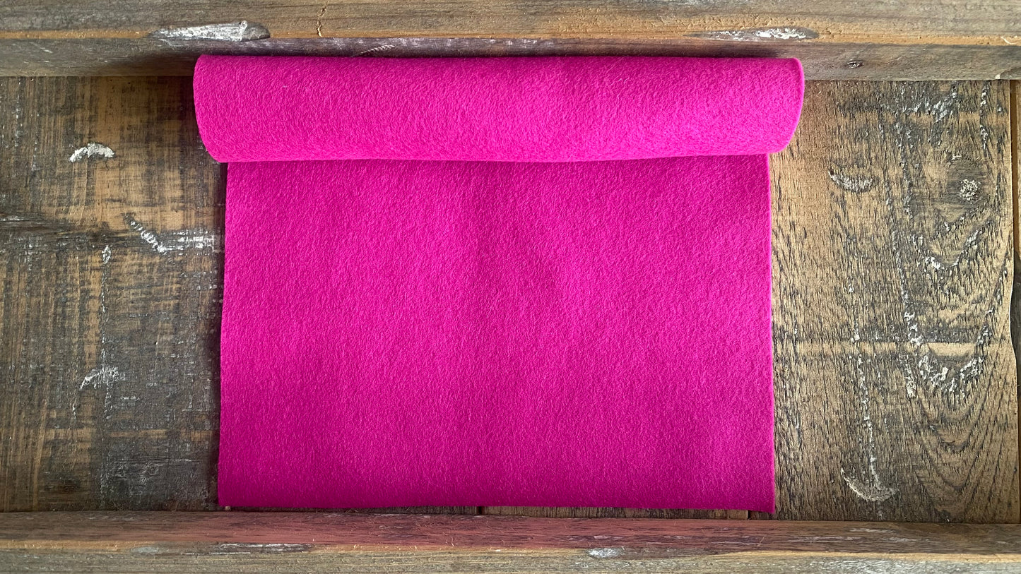 Rolletje wolvilt in de kleur fuchsia nummer 06 op een houten ondergrond voor het maken van viltbloemen, zoals vilten roos, vilten anemoon, vilten pioenroos, hortensia van vilt