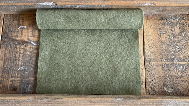 Rolletje wolvilt in de kleur grijs groen nummer 563 op een houten ondergrond voor het maken van viltbloemen, zoals vilten blad, vilten eucalyptus