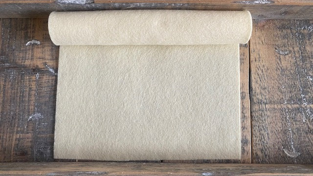 Rolletje wolvilt in de kleur heel licht geel nummer 93 op een houten ondergrond voor het maken van viltbloemen, zoals oa vilten narcis, vilten anemoon