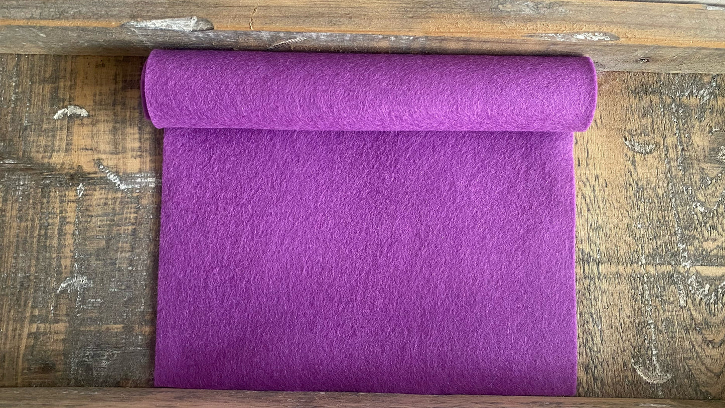 Rolletje wolvilt in de kleur lilaroze nummer 05 op een houten ondergrond voor het maken van viltbloemen, zoals vilten viooltje, vilten anemoon, vilten lavendel, hortensia van vilt