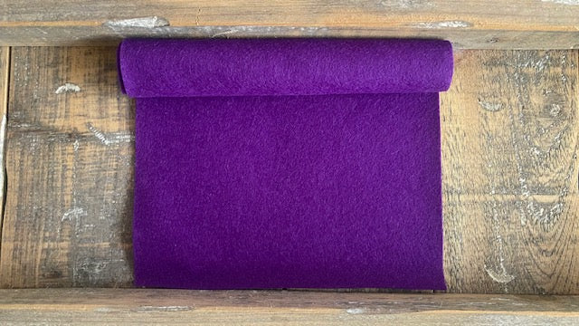 Rolletje wolvilt in de kleur paars nummer 107 op een houten ondergrond voor het maken van viltbloemen, zoals vilten lavendel en hortensia van vilt