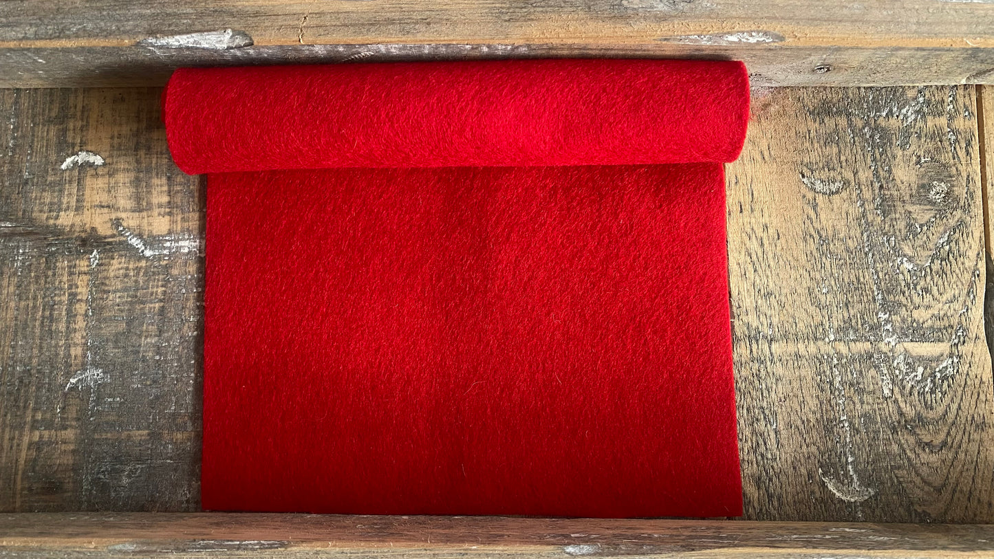 Rolletje wolvilt in de kleur rood nummer 09 op een houten ondergrond voor het maken van viltbloemen
