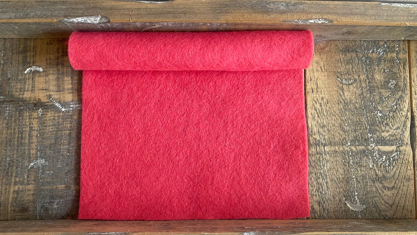 Rolletje wolvilt in de kleur warm roze nummer 632 op een houten ondergrond voor het maken van viltbloemen, zoals vilten roos, vilten magnolia, vilten pioenroos, kersenbloesem van vilt