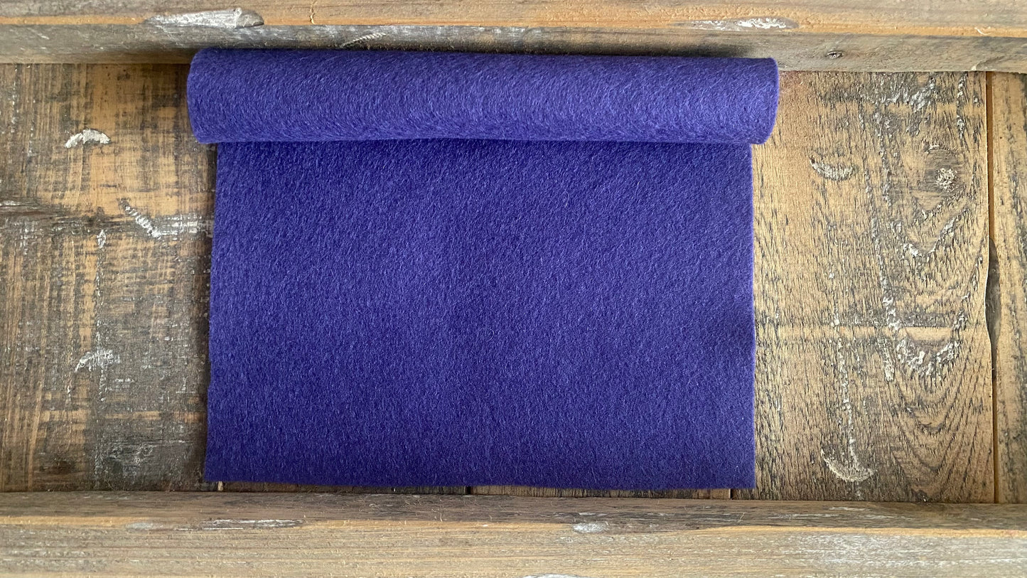 Rolletje wolvilt in de kleur lavendel nummer 74 op een houten ondergrond voor het maken van viltbloemen, zoals vilten lavendel