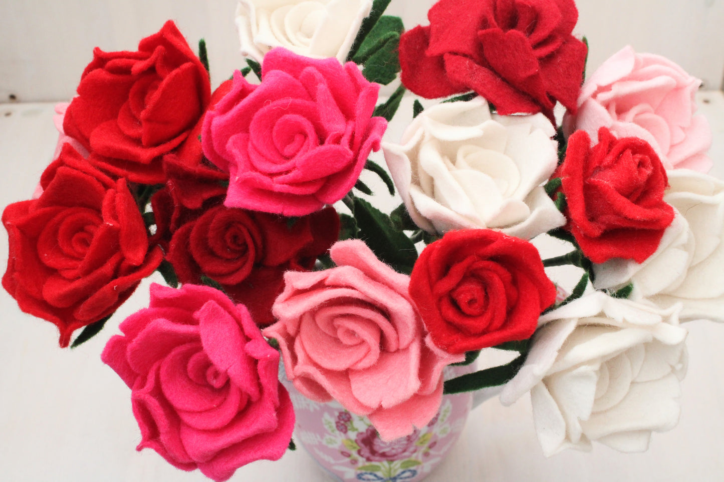 Groot handgemaakt boeket van vilten rozen in verschillende kleuren, met gedetailleerde groene bladeren en stevige stelen. Een tijdloze en duurzame bloemendecoratie, perfect als romantisch cadeau of sfeervolle interieuraccessoire