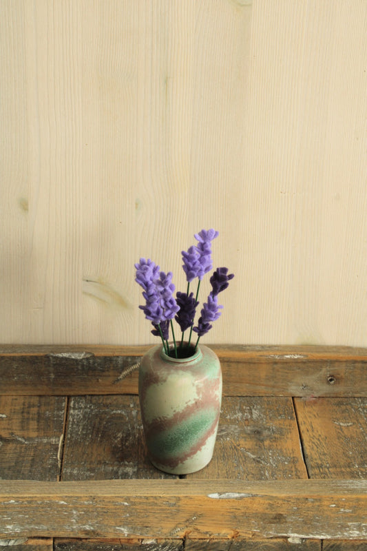 Keramisch vaasje met een gemêleerd glazuur in crèmekleur, groen en roodbruin, perfect voor viltbloemen op een houten ondergrond