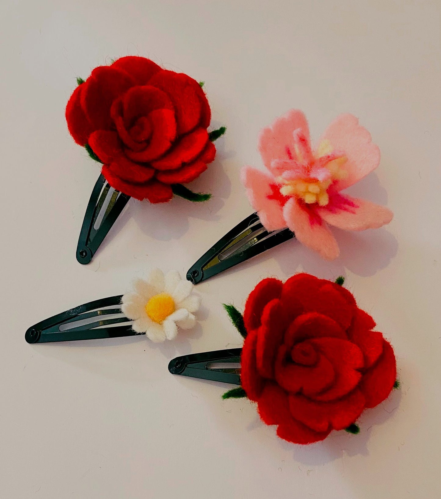 Leuke Handgemaakt Haaraccesoires met viltbloemen, roos, hybiscus, madeliefje op een lichte achtergrond