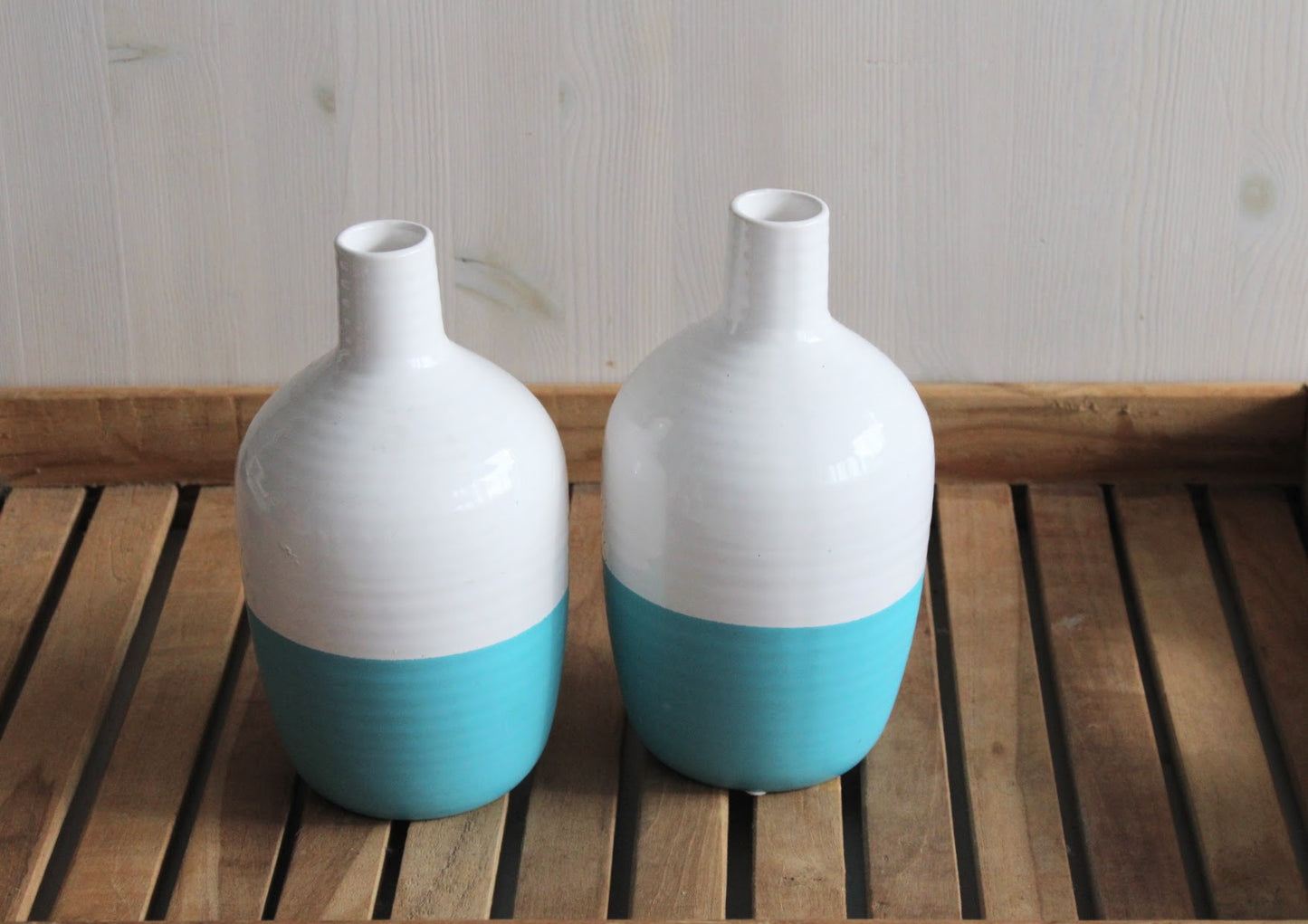 wit met turquoise flesvormige vazen geschikt voor viltbloemen op een houten ondergrond
