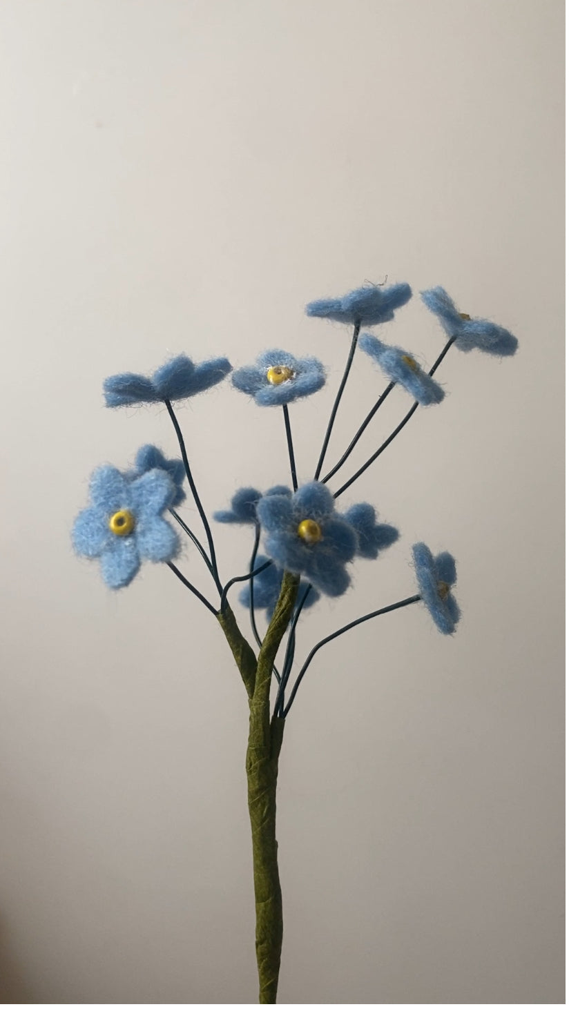 handgemaakt vilten vergeet-me-nietje in de kleur blauw met een geel hartje, als herinnering voor een dierbaar iemand die er niet meer is