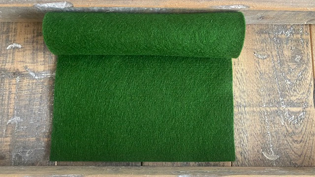 Rolletje wolvilt in de kleur bladgroen nummer 63 op een houten ondergrond voor het maken van viltbloemen