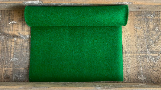 rol groen wolvilt nummer 26 op een houten ondergrond