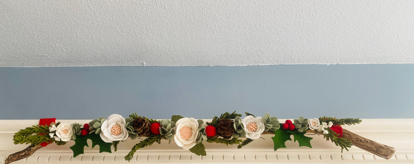 Decoratieve tak met vilten kerstbloemen en groen – originele kerststijl