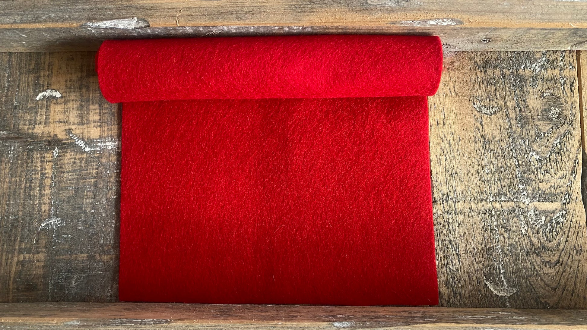 rolletje Rood wolvilt nummer 09 op een houten ondergrond