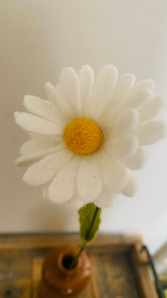 closeup van een handgemaakte viltbloem een witte margriet