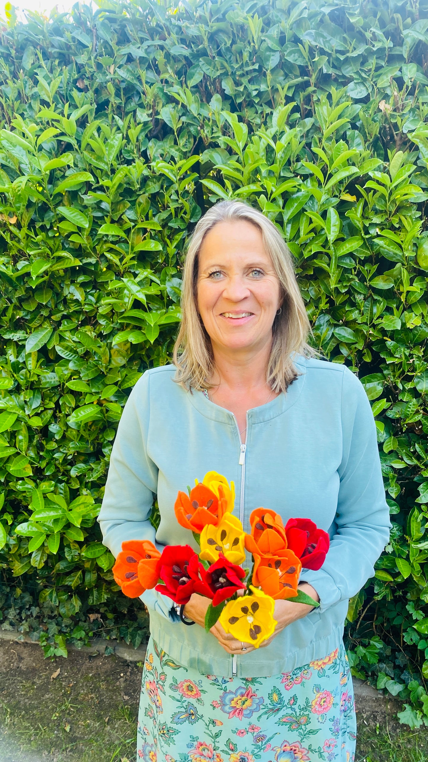 de maker achter het viltbloemenatelier Esther Steur met een bos handgemaakte viltbloemen tulpen
