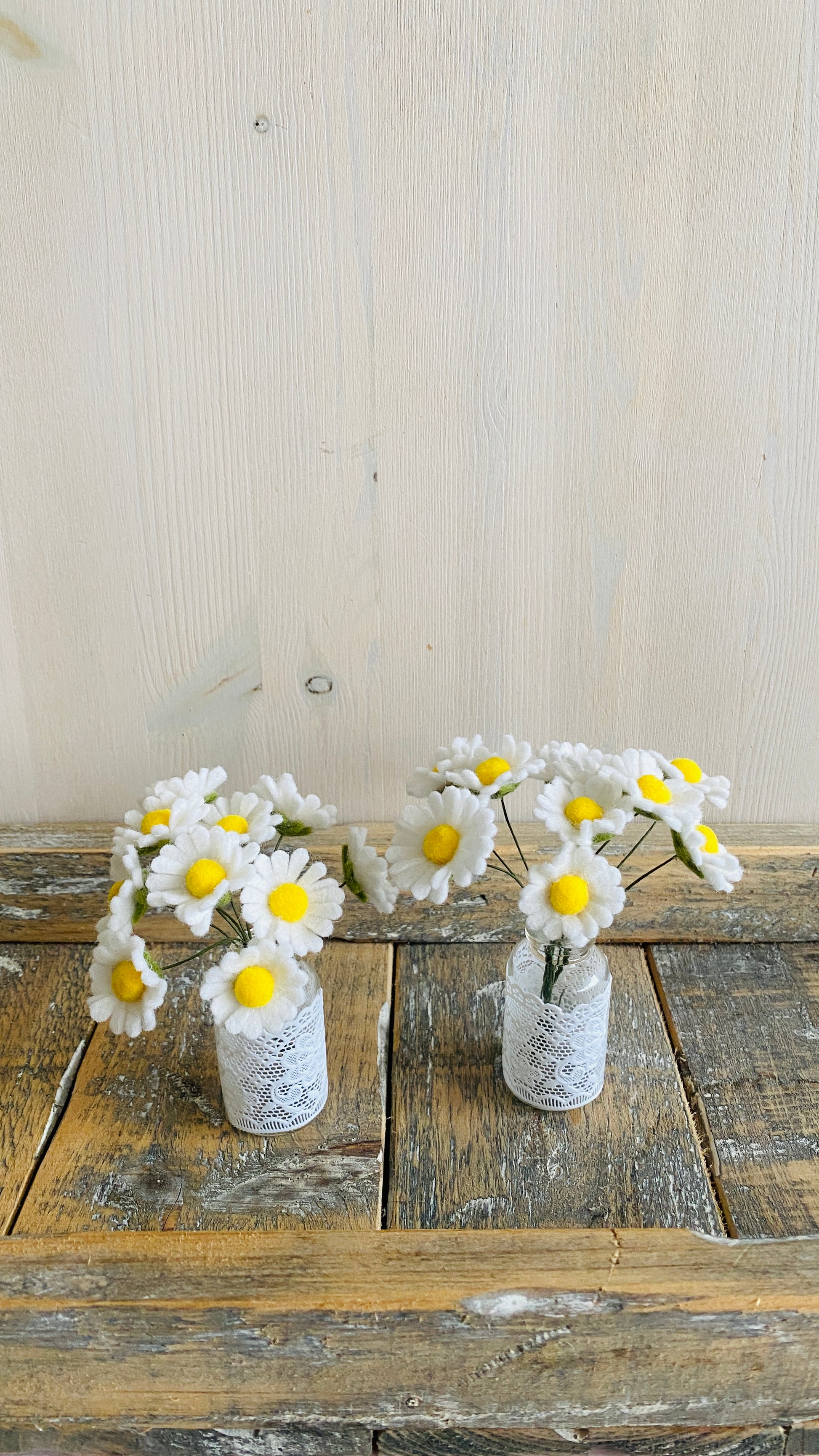 twee handgemaakte viltbloemenboeketjes met madeliefjes van wolvilt