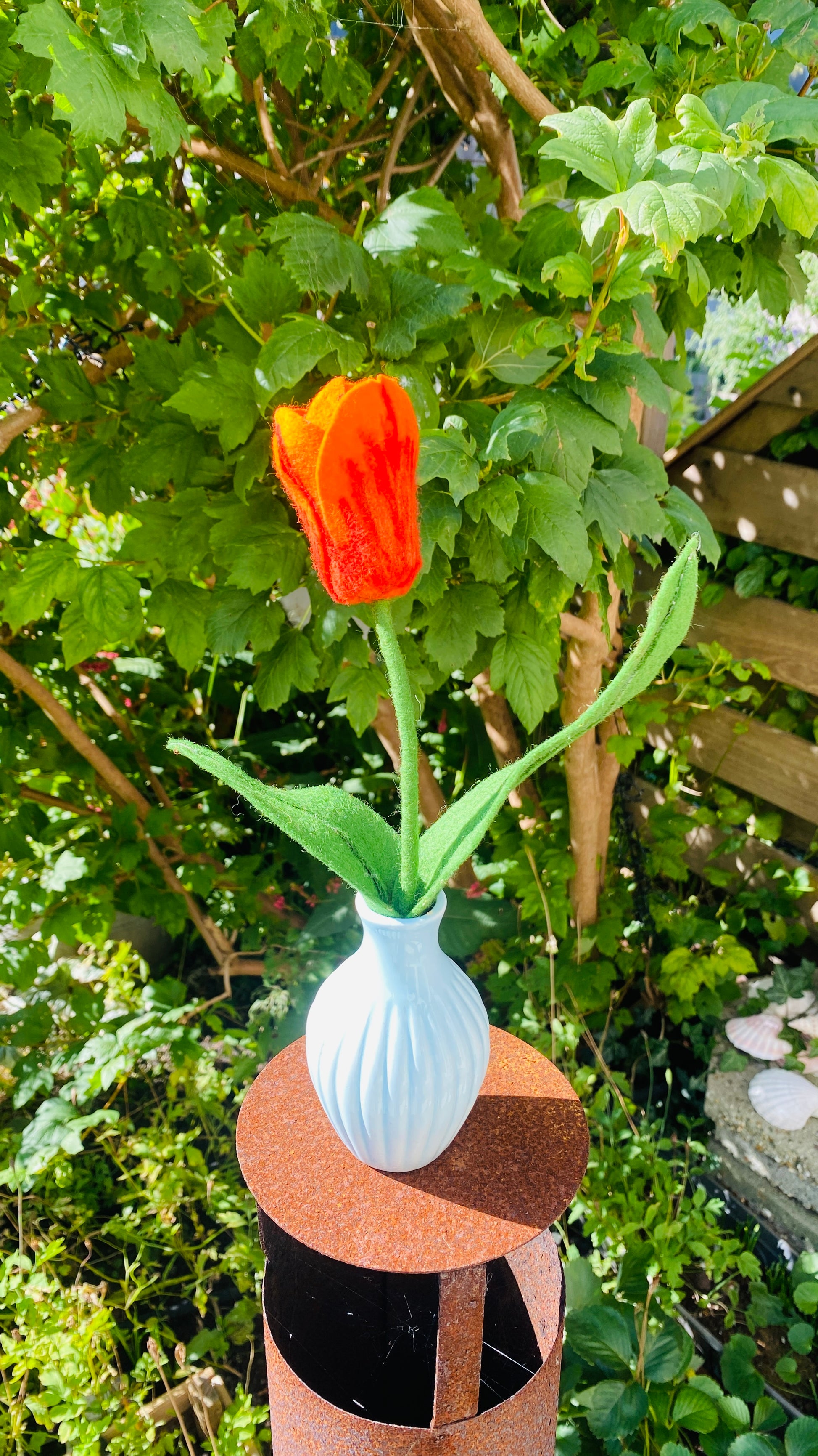 Handgemaakte viltbloem, oranje tulp in een blauw vaasje
