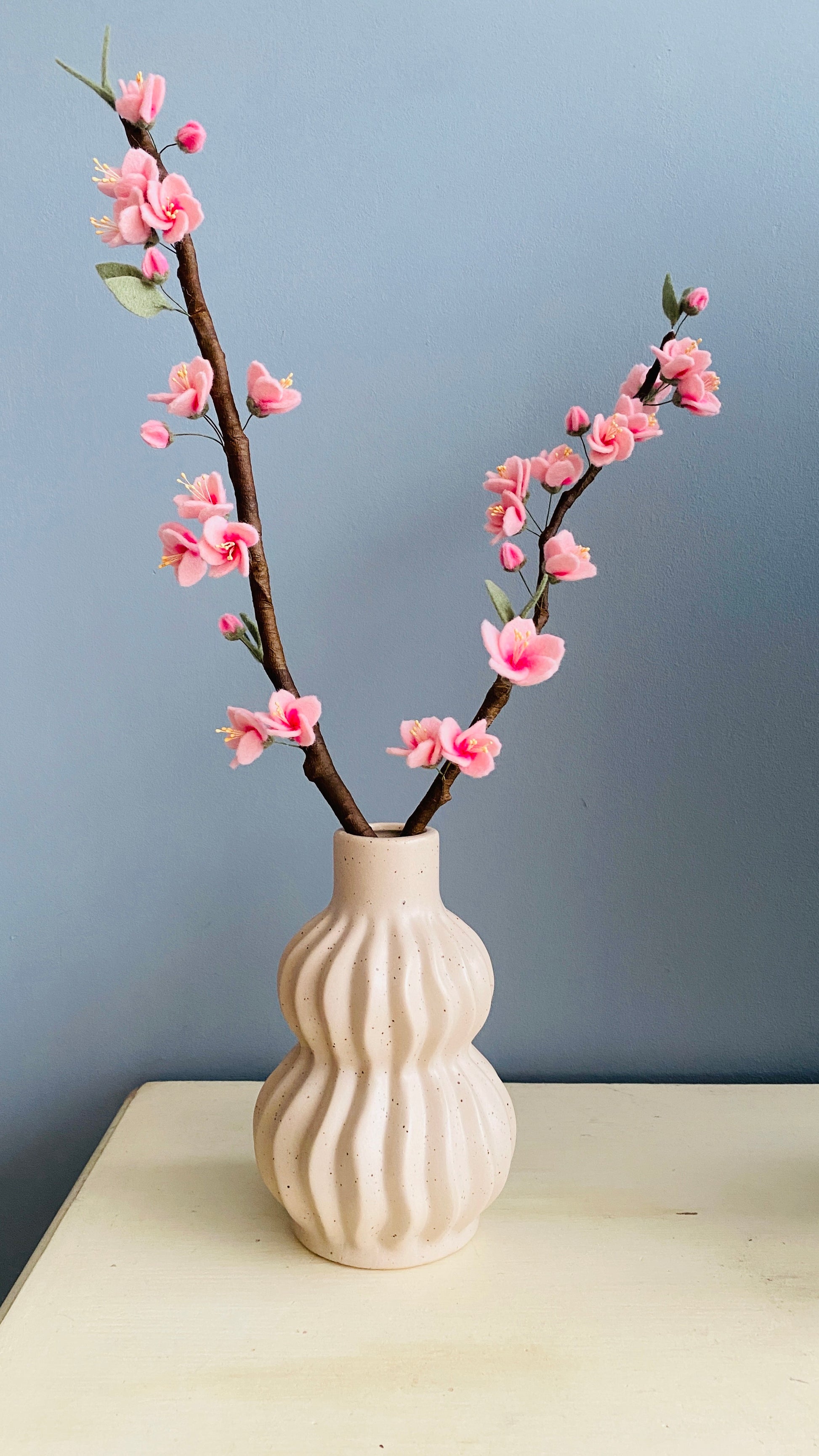 Kersenbloesemtak op maat handgemaakt met kleine roze bloemetjes van vilt bevestigd op een echte tak