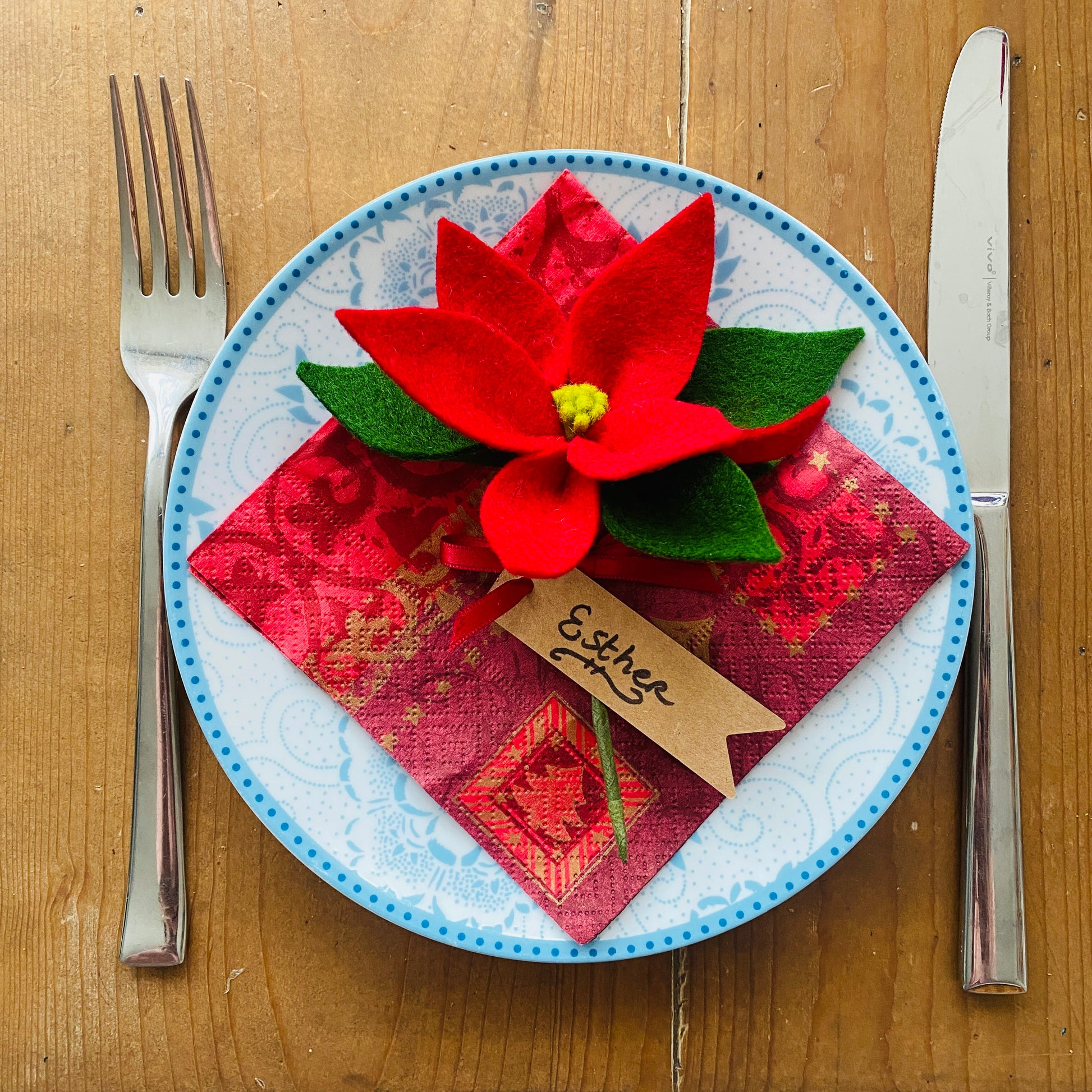 Handgemaakte rode kerstster van vilt als versiering op een bord op de kersttafel gemaakt tijdens de kerstworkshop in uithoorn