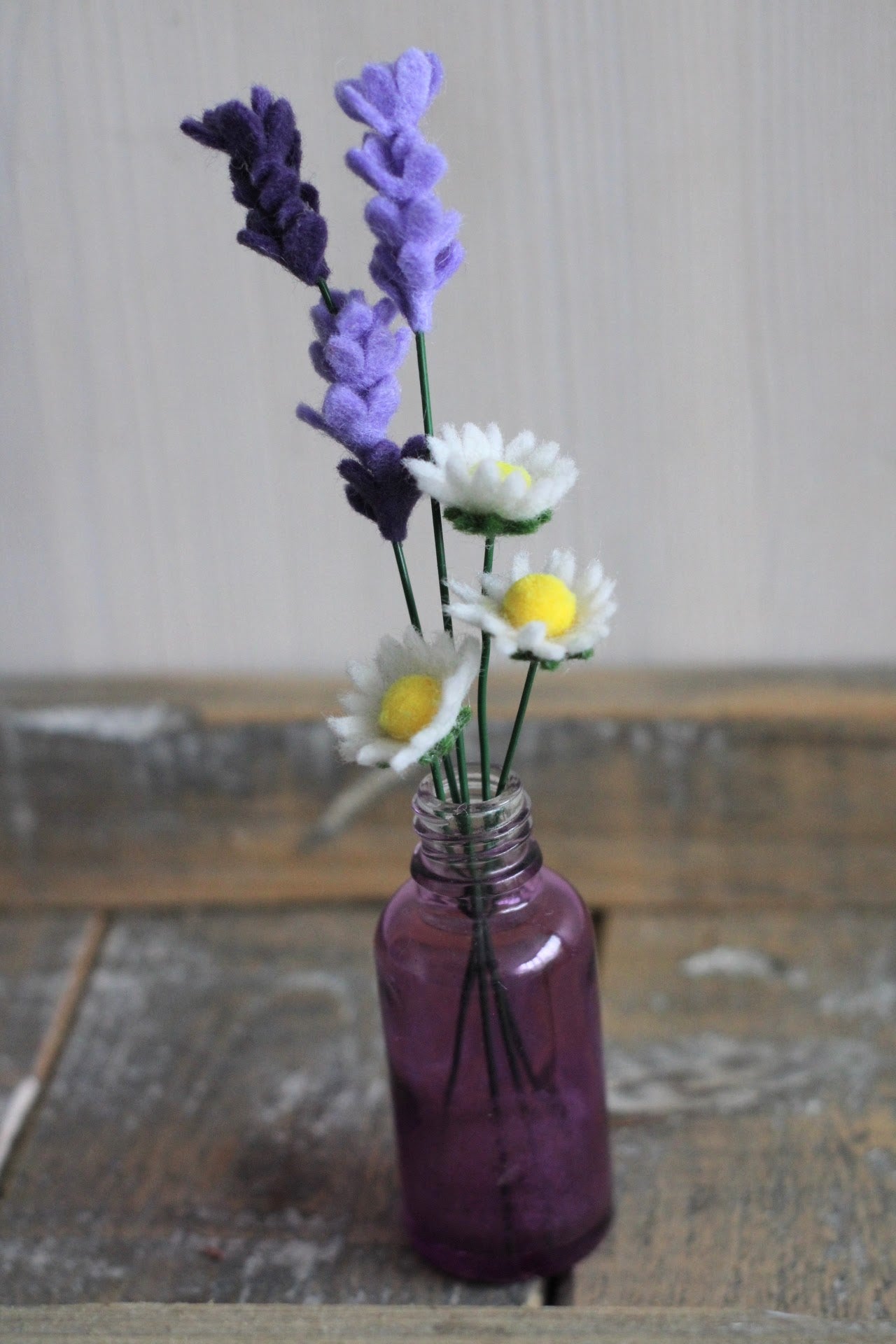 5 handgemaakte mini bloemen van vilt madeliefjes en lavendel in een klein paars vaasje