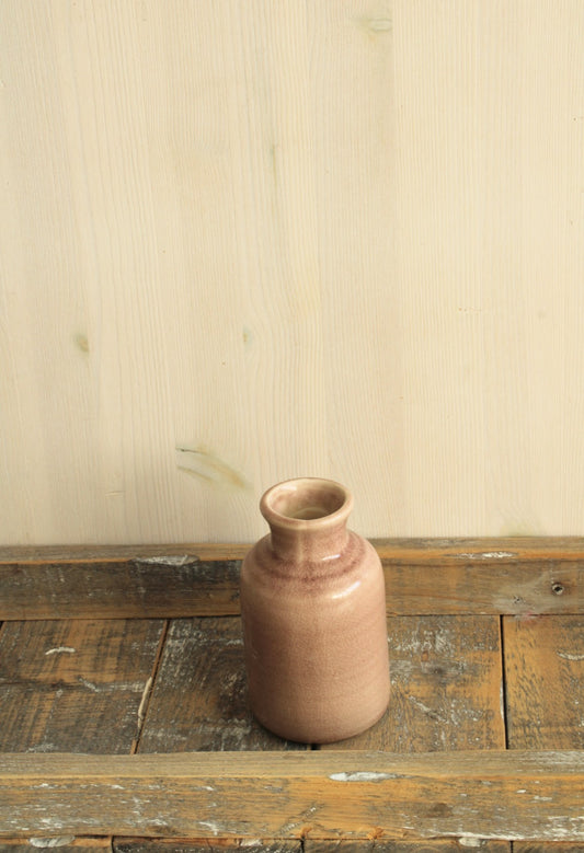 oud roze vaasje voor viltbloemen op een houten ondergrond